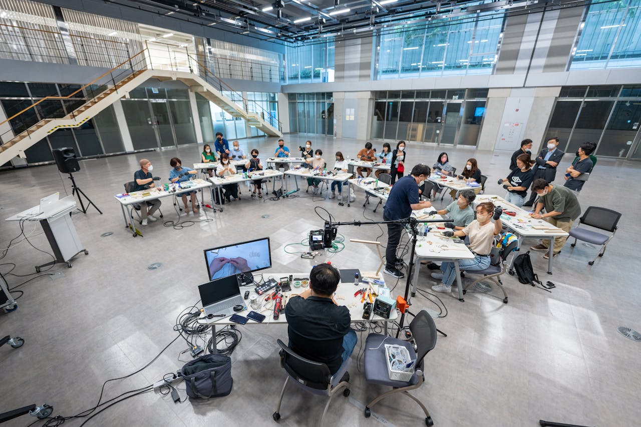 ours-journey Wide shot of students in a modern university classroom engaging with technology and learning.