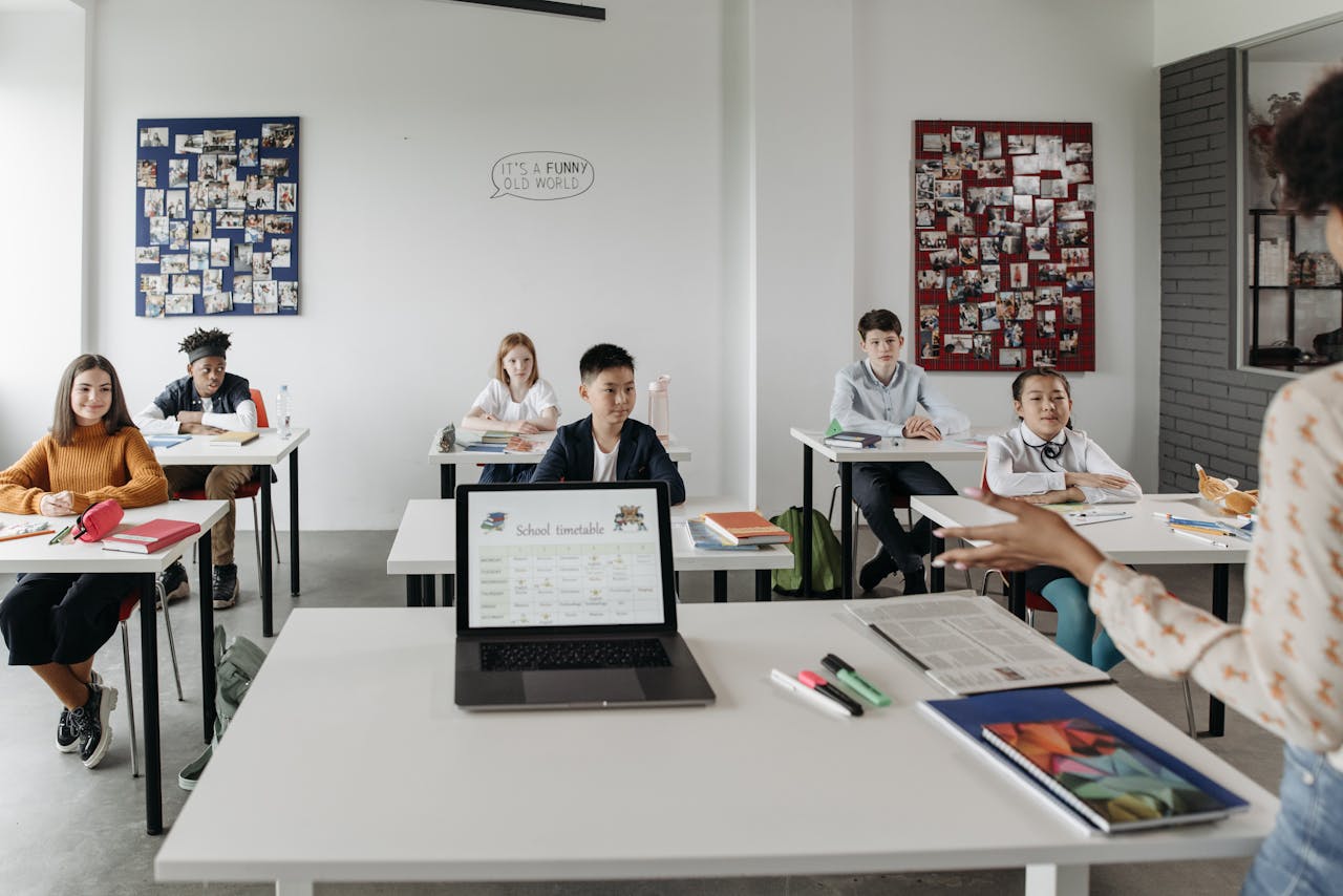 gallery-2 Students in a modern classroom learn with technology under teacher's guidance.